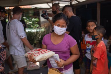 Benoa, Kuta, Kabupaten Badung, Bali, Endonezya - 8 Temmuz 2020: Endonezya 'da maskeli insanların olduğu küçük bir köyün videosu