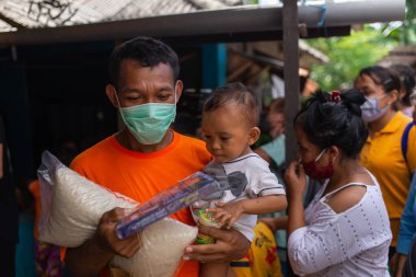 Benoa, Kuta, Kabupaten Badung, Bali, Endonezya - 8 Temmuz 2020: Endonezya 'da maskeli insanların olduğu küçük bir köyün videosu