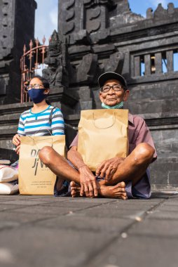 Benoa, Kuta, Kabupaten Badung, Bali, Endonezya - 8 Temmuz 2020: Endonezya 'da maskeli insanların olduğu küçük bir köyün videosu