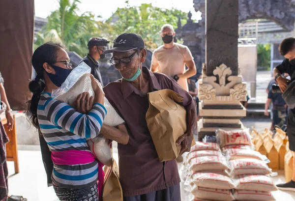Benoa, Kuta, Kabupaten Badung, Bali, Endonezya - 8 Temmuz 2020: Endonezya 'da maskeli insanların olduğu küçük bir köyün videosu