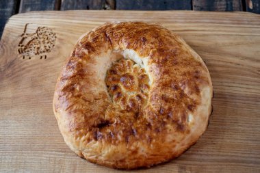 Ahşap bir tahtanın üzerinde nefis taze tandoor ekmeği. Orta Asya ve Orta Doğu 'da ekmek