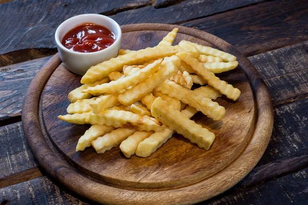 Patates kızartması ve ketçap, tahta kesim tahtası, ahşap sırtı.