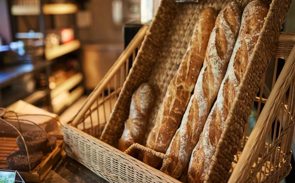 Tahta bambu sepetinde taze ekmek ile sıfır atık kavramı. Dükkanda plastiksiz, taze pişmiş güzel bir arka planda.