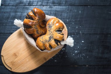 Ahşap arka plan üzerinde haşhaş tohumu ile tatlı çörek. Üstten görünüm. Kopya alanı