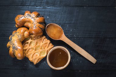 Tatlı çörekler ve siyah ahşap baclground tatlım. Üstten görünüm. Kopya alanı
