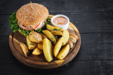 Ahşap tahta üzerinde kızarmış patates ile lezzetli burger