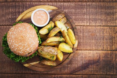 Ahşap tahta üzerinde kızarmış patates ile lezzetli burger