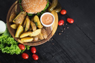 Ahşap tahta üzerinde kızarmış patates ile lezzetli burger