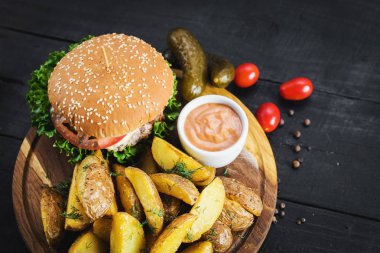 Ahşap tahta üzerinde kızarmış patates ile lezzetli burger