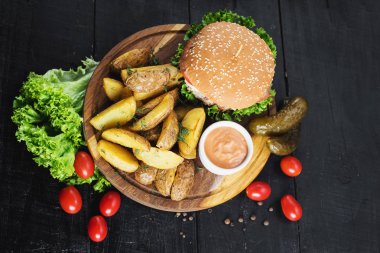 Ahşap tahta üzerinde kızarmış patates ile lezzetli burger