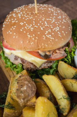 Ahşap tahta üzerinde kızarmış patates ile lezzetli burger
