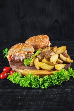 Ahşap tahta üzerinde kızarmış patates ile lezzetli burger