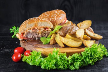 Ahşap tahta üzerinde kızarmış patates ile lezzetli burger