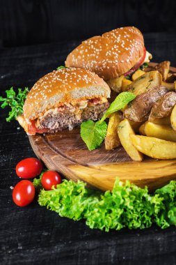 Ahşap tahta üzerinde kızarmış patates ile lezzetli burger