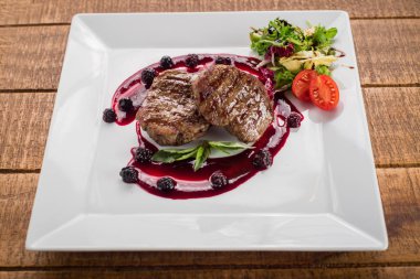 Ahşap arka plan üzerinde raspberrie soslu et biftek ızgara