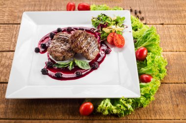 Ahşap arka plan üzerinde raspberrie soslu et biftek ızgara