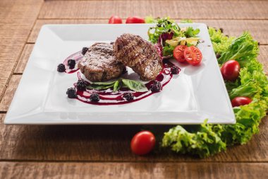 Ahşap arka plan üzerinde raspberrie soslu et biftek ızgara