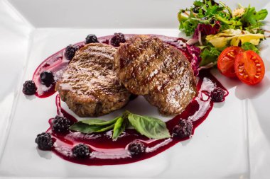 Ahşap arka plan üzerinde raspberrie soslu et biftek ızgara