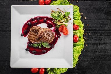 Ahşap arka plan üzerinde raspberrie soslu et biftek ızgara