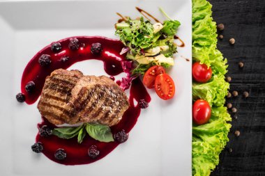 Ahşap arka plan üzerinde raspberrie soslu et biftek ızgara