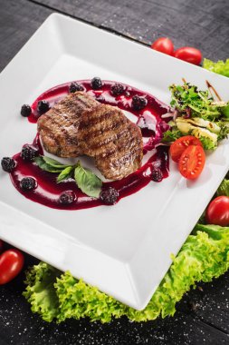 Ahşap arka plan üzerinde raspberrie soslu et biftek ızgara