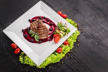 Ahşap arka plan üzerinde raspberrie soslu et biftek ızgara