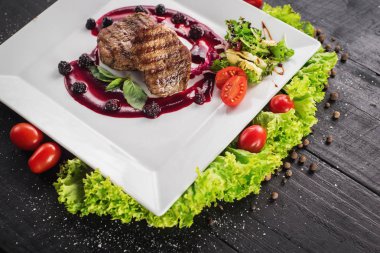 Ahşap arka plan üzerinde raspberrie soslu et biftek ızgara