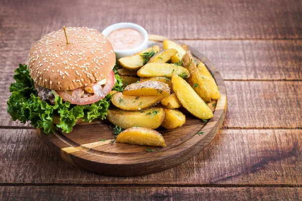 Ahşap tahta üzerinde kızarmış patates ile lezzetli burger