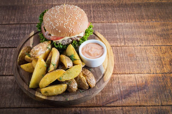 Ahşap tahta üzerinde kızarmış patates ile lezzetli burger