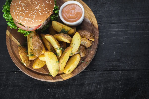 Ahşap tahta üzerinde kızarmış patates ile lezzetli burger