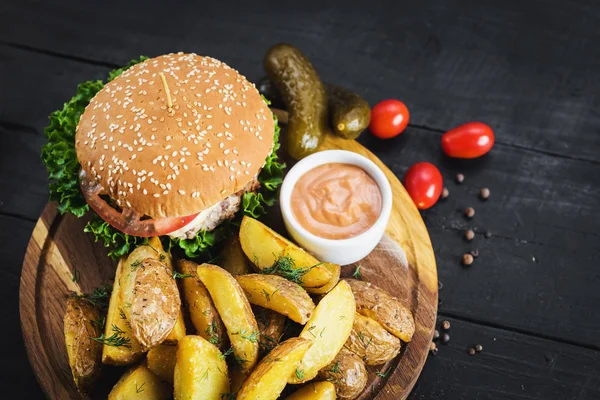 Ahşap tahta üzerinde kızarmış patates ile lezzetli burger