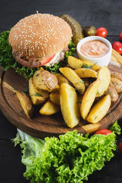 Ahşap tahta üzerinde kızarmış patates ile lezzetli burger