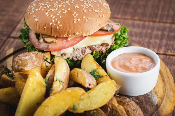 Ahşap tahta üzerinde kızarmış patates ile lezzetli burger