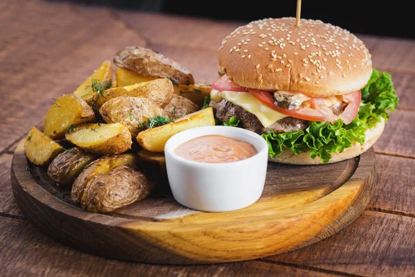 Ahşap tahta üzerinde kızarmış patates ile lezzetli burger
