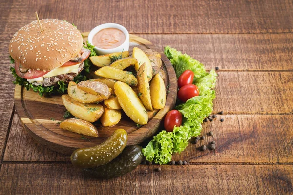 Ahşap tahta üzerinde kızarmış patates ile lezzetli burger