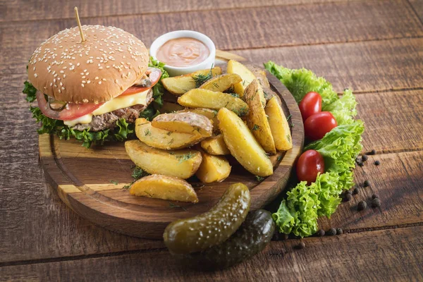 Ahşap tahta üzerinde kızarmış patates ile lezzetli burger