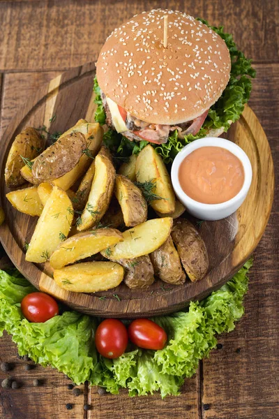 Ahşap tahta üzerinde kızarmış patates ile lezzetli burger