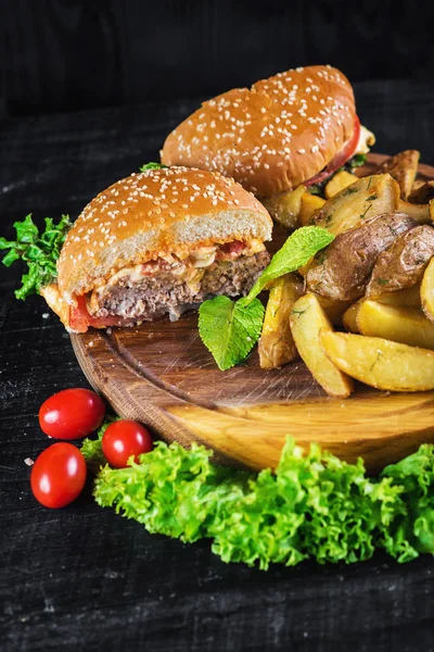 Ahşap tahta üzerinde kızarmış patates ile lezzetli burger