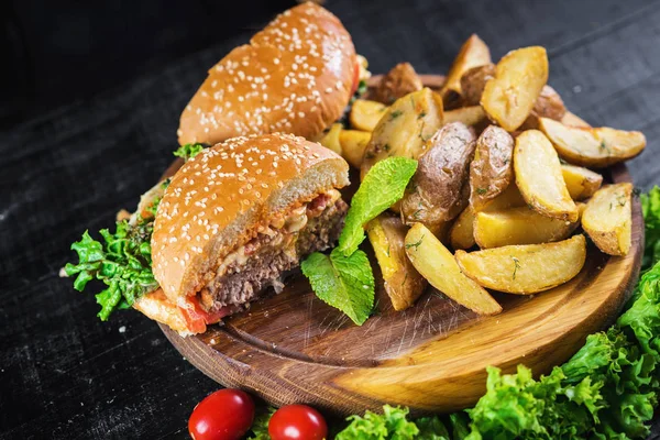Ahşap tahta üzerinde kızarmış patates ile lezzetli burger
