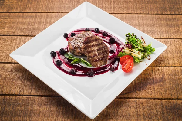 Ahşap arka plan üzerinde raspberrie soslu et biftek ızgara