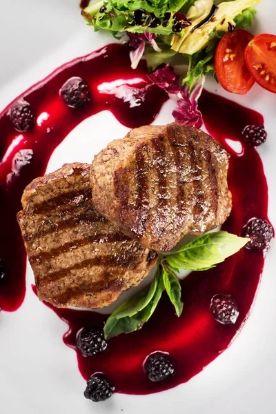 Ahşap arka plan üzerinde raspberrie soslu et biftek ızgara