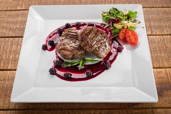 Ahşap arka plan üzerinde raspberrie soslu et biftek ızgara