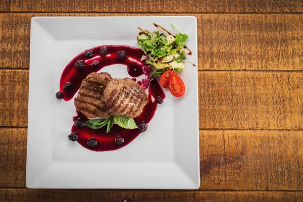 Ahşap arka plan üzerinde raspberrie soslu et biftek ızgara