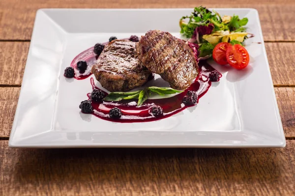 Ahşap arka plan üzerinde raspberrie soslu et biftek ızgara