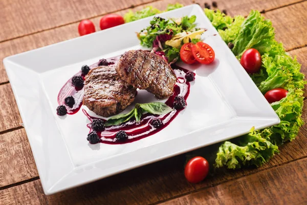Ahşap arka plan üzerinde raspberrie soslu et biftek ızgara
