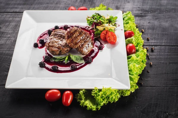 Ahşap arka plan üzerinde raspberrie soslu et biftek ızgara