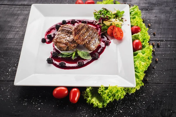 Ahşap arka plan üzerinde raspberrie soslu et biftek ızgara
