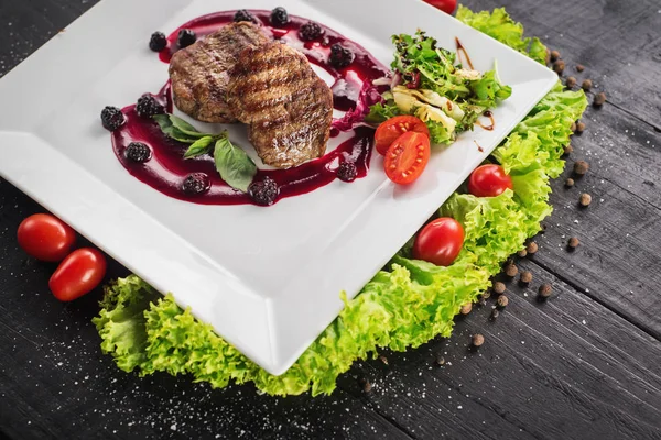Ahşap arka plan üzerinde raspberrie soslu et biftek ızgara