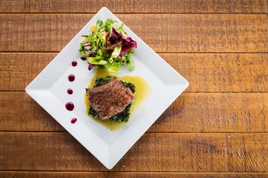 Kızarmış parça et otlar ve baharatlar ahşap arka plan üzerinde