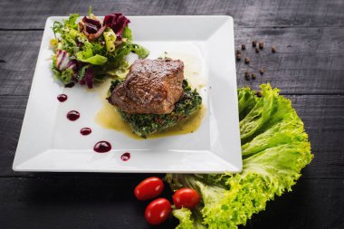 Kızarmış parça et otlar ve baharatlar ahşap arka plan üzerinde